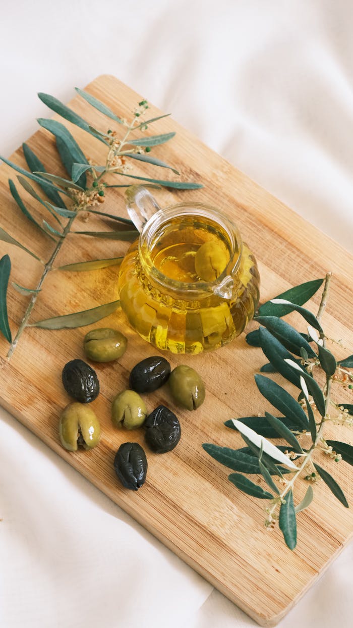 The Art of Drawing Readers In: Your attractive post title goes here Cozy setup featuring olives and olive oil on a wooden board with olive branches.